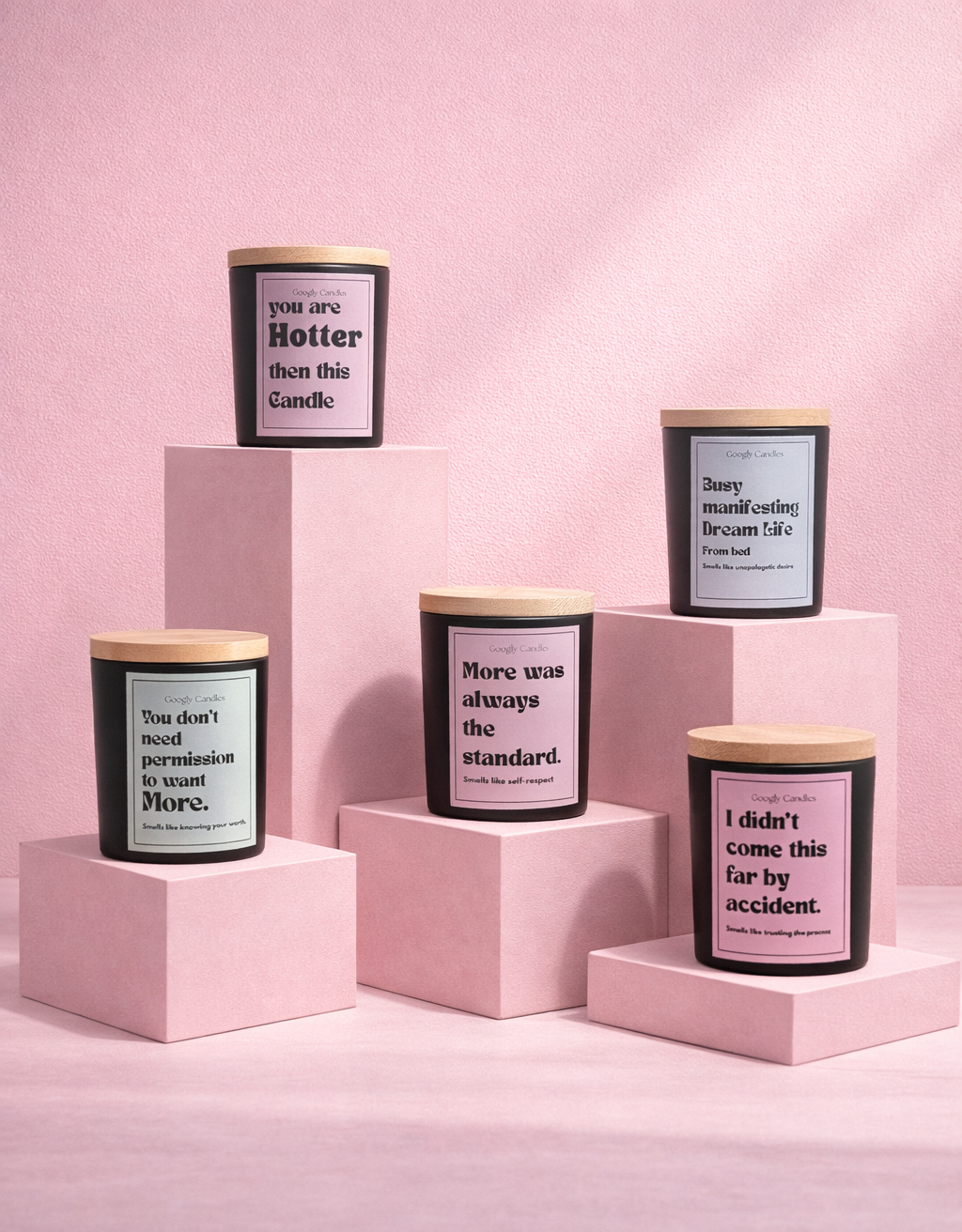 Five candles on pink stands with motivational text against a pink background